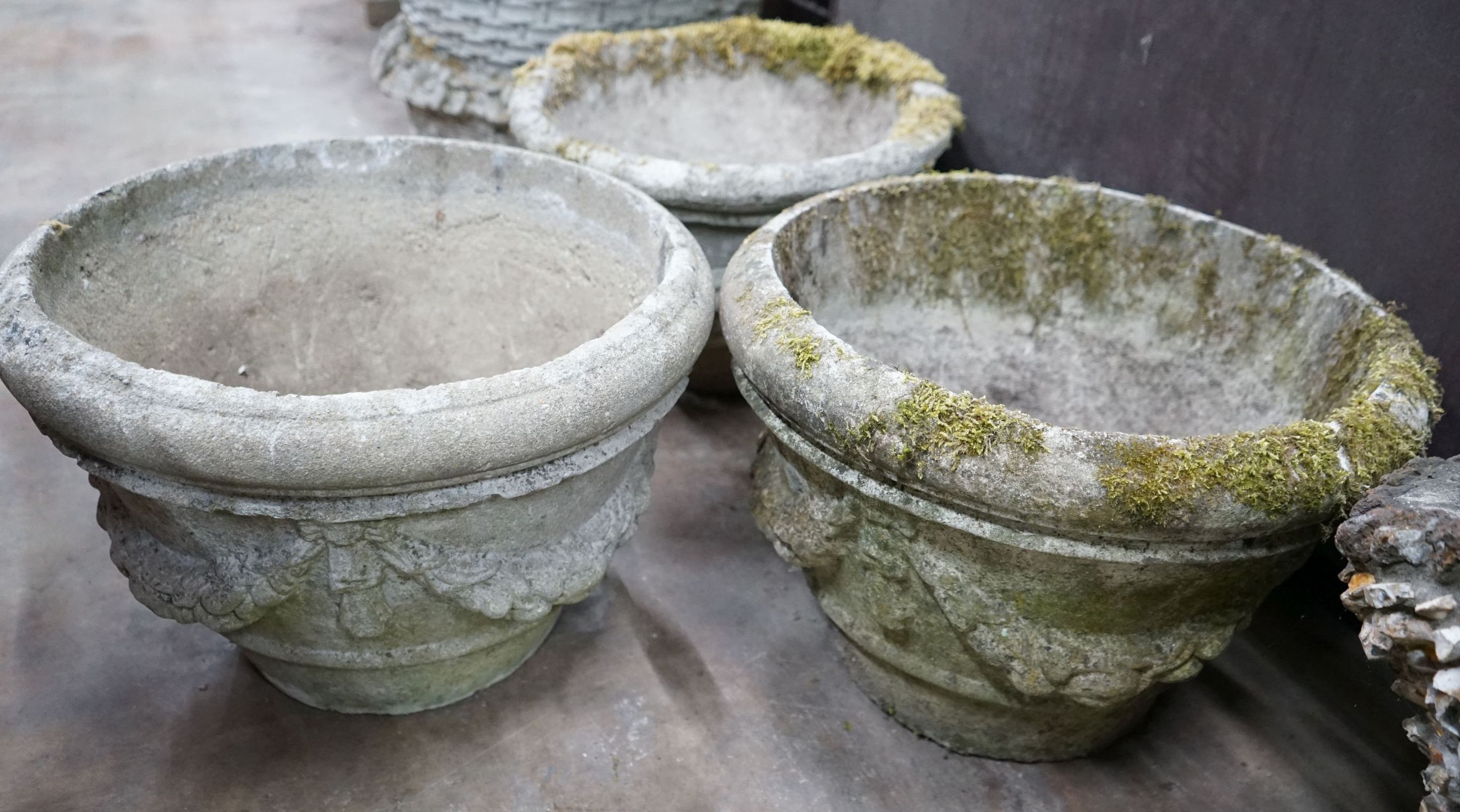A set of three circular reconstituted stone garden planters with swagged bodies, diameter 48cm, height 32cm